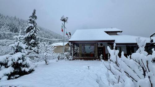 a house covered in snow in front at Dolphin Residence Bulgaria in Zgorigrad