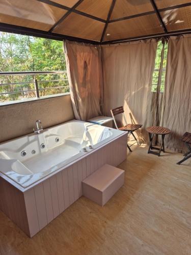 a large tub in a tent with a table and chairs at Coco Villa with Private Pool in Karjat