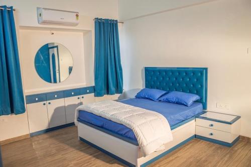 a bedroom with a blue bed and a mirror at Coco Villa with Private Pool in Karjat