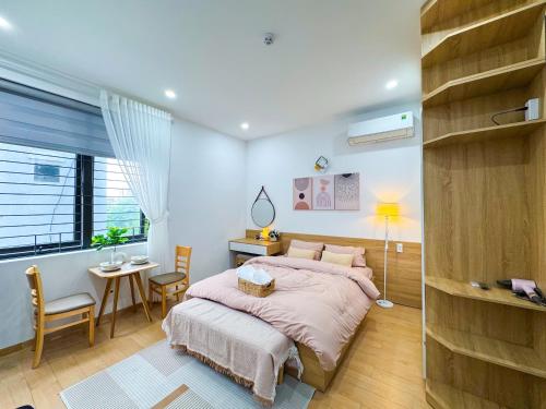 een slaapkamer met een bed, een tafel en een stoel bij BaBô Homestay Da Nang in Da Nang