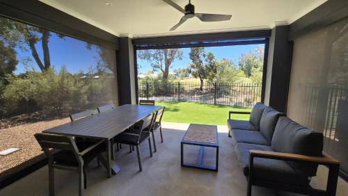 a dining room with a table and a large window at Silverwoods 17th Hole Retreat in Yarrawonga