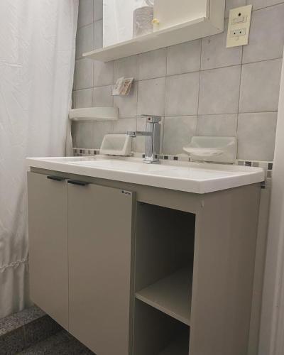 ein Badezimmer mit einem weißen Waschbecken und einem Spiegel in der Unterkunft Patri Hotel in Chivilcoy