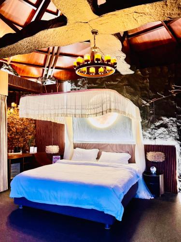 a bedroom with a white bed with a chandelier at Forest 101 in Infanta