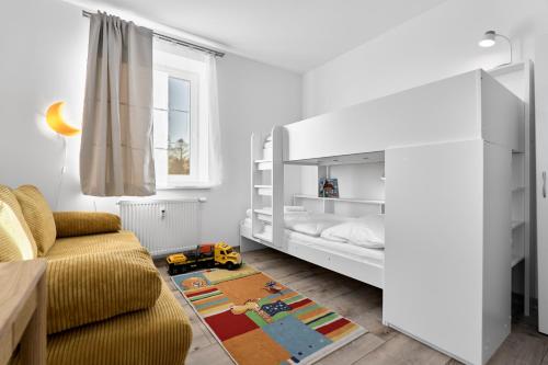 een kinderkamer met een bed en een gele bank bij George 01 by Mountain ways in Kovářská