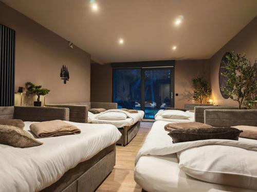 een kamer met 4 bedden in een kamer met een raam bij L'écrin de la forêt in Jeanménil