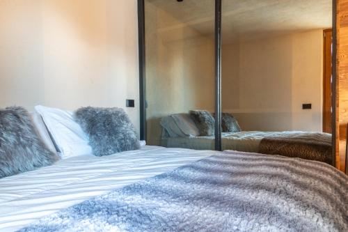 ein Schlafzimmer mit einem Bett mit einem großen Spiegel in der Unterkunft HelloCHALET - The Alpine Suite - Central Studio, Walk to Slopes in Breuil-Cervinia