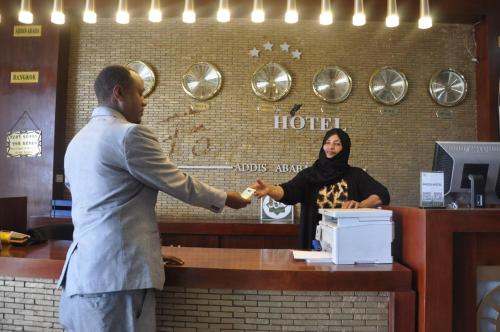 un uomo e una donna che si stringono la mano a uno sportello di Foyat Hotel ad Addis Abeba