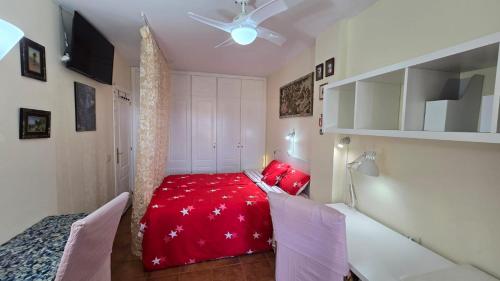 een slaapkamer met een rood bed en 2 stoelen bij Tenerife flyport in San Isidro