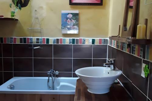 een badkamer met een bad en een wastafel bij Au restalèz in Trémargat