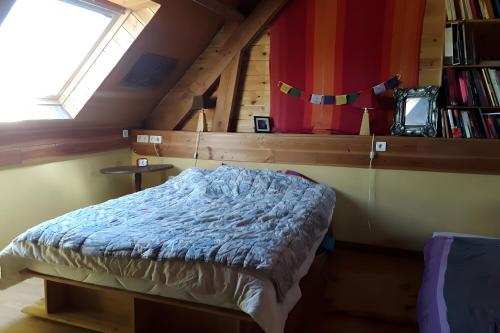 een slaapkamer met een bed, een raam en boeken bij Au restalèz in Trémargat