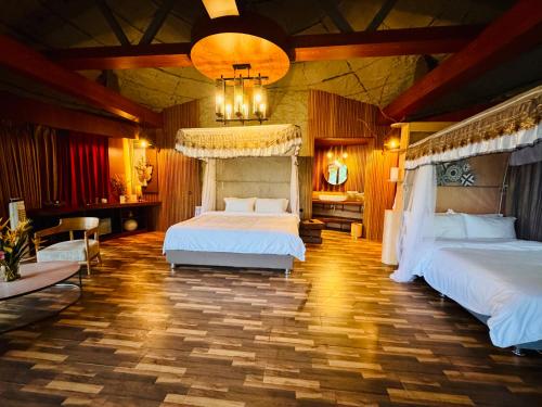 una camera da letto con due letti e un lampadario di Forest 101 a Infanta