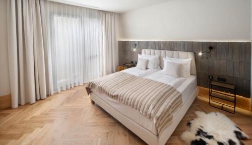 une chambre avec un grand lit et une grande fenêtre dans l'établissement Skigyimes Hotel, à Lunca de Sus