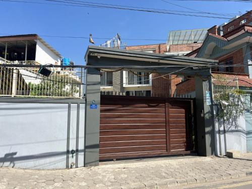 une maison avec une porte de garage en bois dans une rue dans l'établissement Triluna Apartments, à Pātan