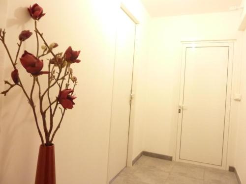 a vase with red roses in a room at Studio meublé Centre ville in Bastia