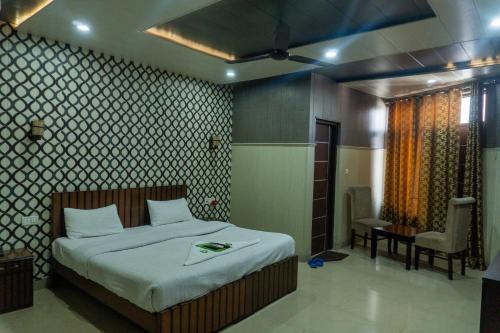 een slaapkamer met een bed en een stoel erin bij Krazy Hotel in Haldwani