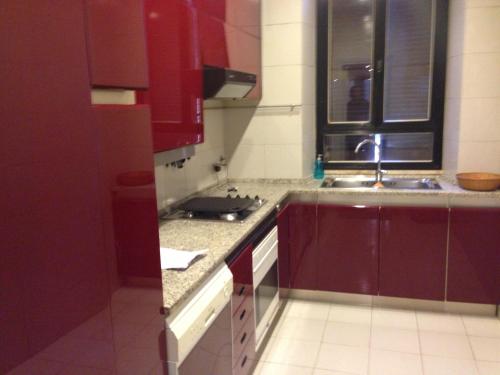 uma cozinha com armários vermelhos e um lavatório em Luxury ai Banchi Nuovi em Roma