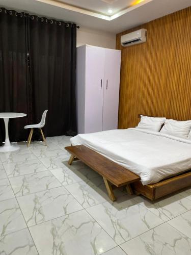 a bedroom with a bed and a table and a chair at Boho apartment and spa in Lekki