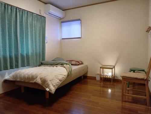 a small bedroom with a bed and a window at 民泊kururu 個室 鍵付き朝パン付きライダー用ガレージ有り in Nishidani