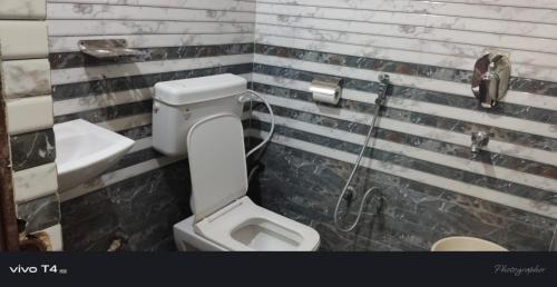 een badkamer met een toilet en een douche bij Shree Radha Raman Palace in Ayodhya