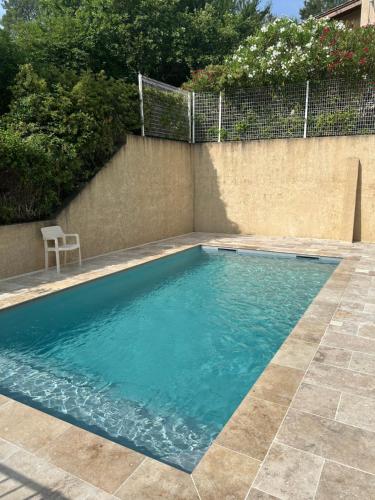 einen Pool mit einem Stuhl neben einer Wand in der Unterkunft Bel appart - 3 ch Vallon pont d 'arc in Salavas