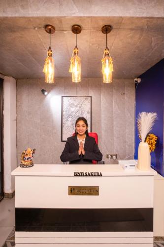 a woman sitting at a desk in a room at Bnb Sakura , Golf Course Road in Gurgaon