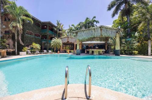 - une grande piscine dans un complexe avec des palmiers dans l'établissement Host Company Jaco Luxury, à Jacó