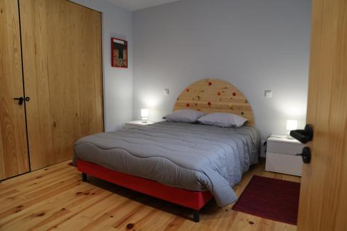een slaapkamer met een groot bed met een houten hoofdeinde bij MedronHouse - Casa de Campo in Vasco Esteves de Baixo