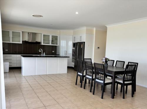 a kitchen with a black table and chairs and a counter at Riviera Caravan Park in Sussex inlet