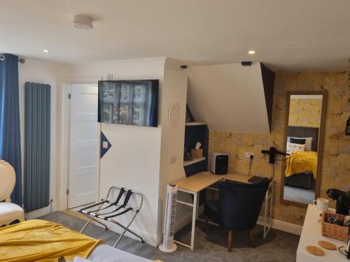 een kleine kamer met een bureau en een slaapkamer bij Copperbeech B&B in Yoxford