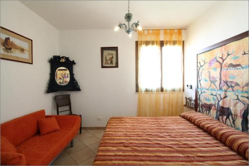 a bedroom with a bed and a couch and a window at Senia in San Vito lo Capo