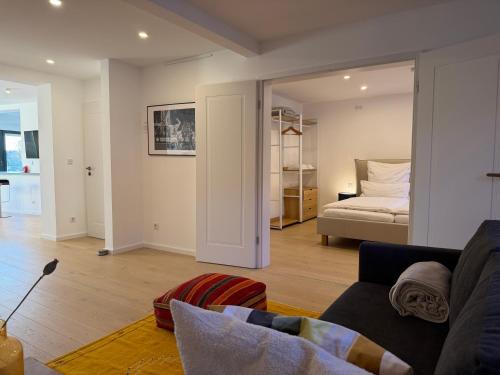 een woonkamer met een bank en een bed bij Silk House - Designerwohnung nahe Düsseldorf in Krefeld