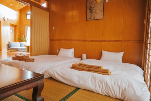 a bedroom with two beds with white sheets at Nagoya in Nakijin
