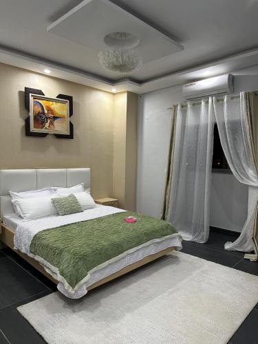 una camera da letto con un letto grande con una coperta verde di résidence Manolie a Abidjan