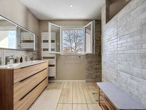 een badkamer met een wastafel en een raam bij Escale et Séjour in Lavaur