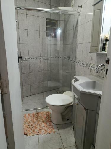 a bathroom with a shower and a toilet and a sink at Doce aconchego in Pato Branco