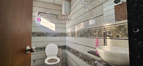 a bathroom with a sink and a toilet at Hotel Jalsa in Surat