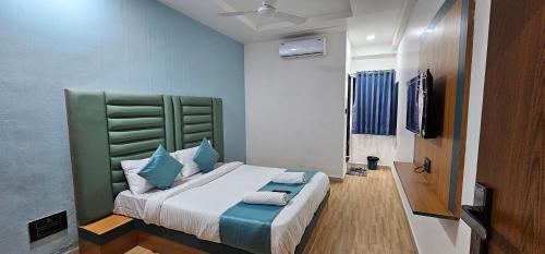a bedroom with a large bed with blue pillows at Hotel Jalsa in Surat