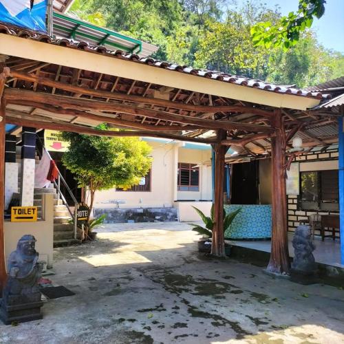 an outdoor patio with a wooden pergola at Baronsari GuestHouse in Pulau Kukup