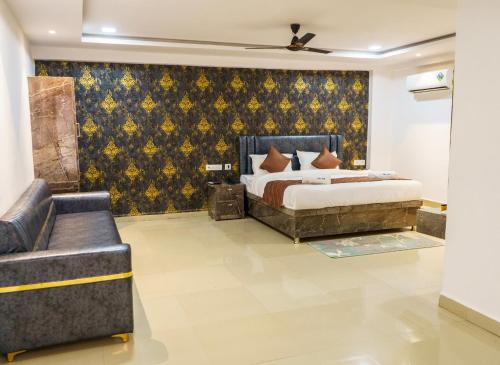 a bedroom with a bed and a couch at Hotel Park View in Akolia