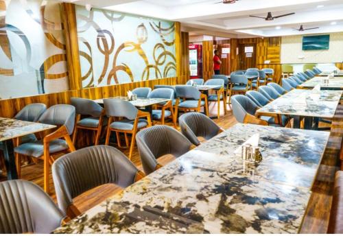 a dining room with tables and chairs in a restaurant at Hotel Park View in Akolia
