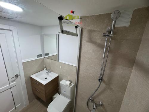 a bathroom with a shower and a toilet and a sink at Casa Dudu in Corralejo