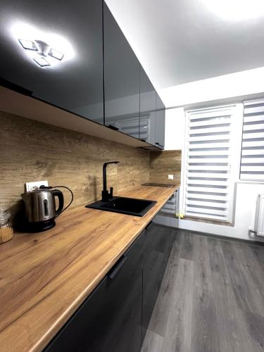 een keuken met een houten aanrecht met een wastafel bij LuRo Loft Otopeni in Otopeni