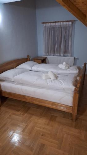 a bedroom with a bed with white sheets and a window at Kuća za odmor Diva Blidinje, Risovac 455 in Blidinje