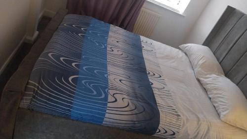 een bed met een blauwe en witte deken erop bij High class accommodations 10 in Little Hulton