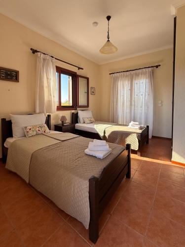 a bedroom with two beds and a living room at Villa Palmera 100m from the beach in Nikiti