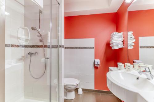 ein Badezimmer mit Dusche, Toilette und Waschbecken in der Unterkunft Ace Hotel Montluçon in Saint-Victor