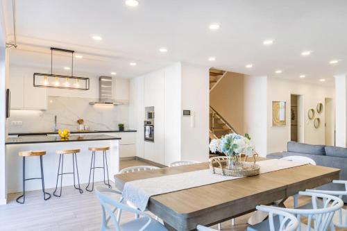 a kitchen and living room with a wooden table and chairs at LUX House in Ponta Delgada