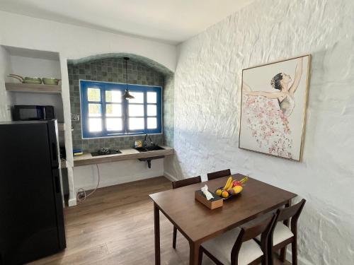 a dining room with a table and a kitchen at Casa Bella Khaolak in Khao Lak