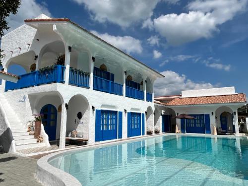 a villa with a swimming pool in front of a building at Casa Bella Khaolak in Khao Lak