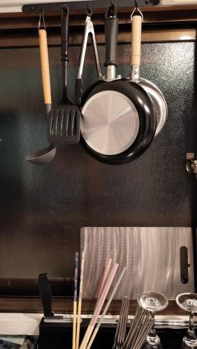 a bunch of cooking utensils hanging from a ceiling at 102個室元芸者の隠れ宿湯河原 in Yugawara